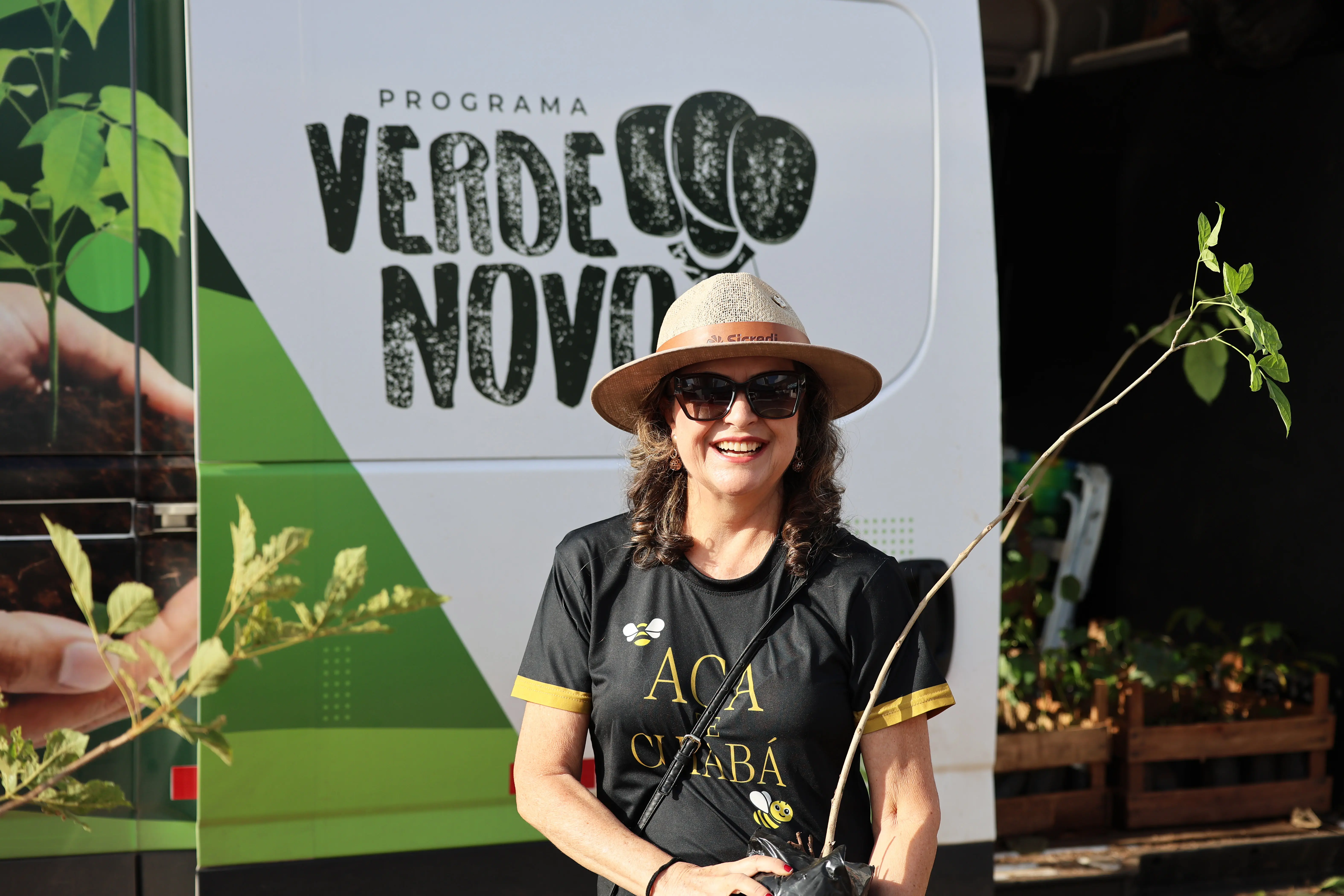 Mulher de chapéu, óculos escuros e camiseta preta 